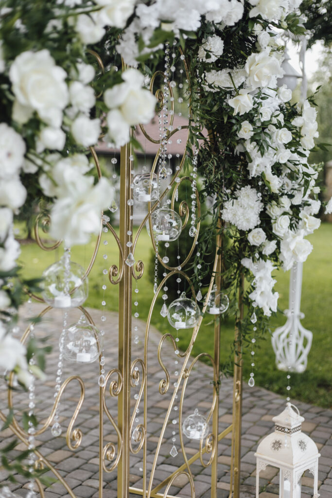 forged gates are decorated with fresh white flowers and greenery